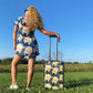 wheaten puppy design carry-on suitcase, with model in wheaten puppy t-shirt dress from the back